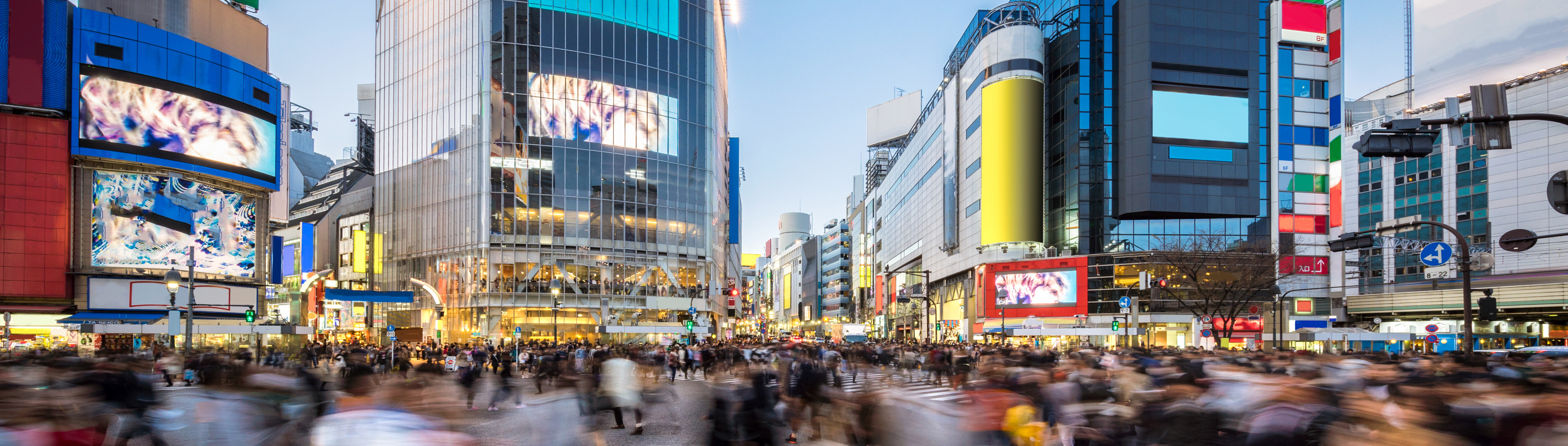 Busy crossin g with pedestrians in Tokyo with colourfull builidings in the background